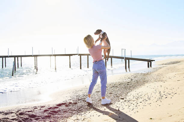 istock Women and Dog at the Beach 1133463449
