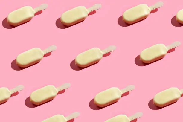 White chocolate ice cream popsicle pattern on pink background