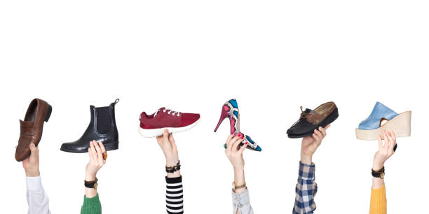 istock Hands holding different shoes on isolated background 1133465161