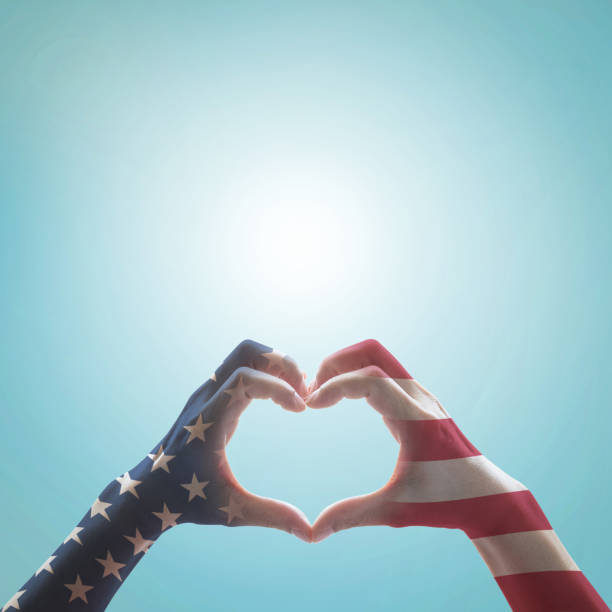 American flag pattern on people hands in heart shaped form against vintage sky background w/ clouds: Memorial day Happy columbus day Patriot day, USA Independence Labor Loyalty day symbolic concept patrón de la bandera americana en las manos de las personas en forma de corazón contra el fondo de cielo vintage w/nubes: día de conmemoración feliz día de colón patriota día, estados unidos independencia laboral día de lealtad concepto simbólico