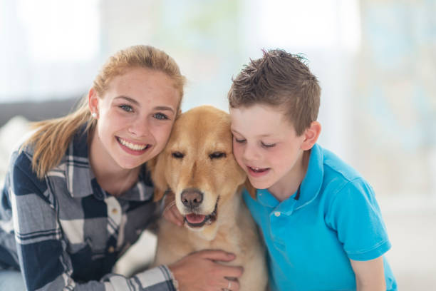 istock Portrait of siblings hugging their dog 1133468354