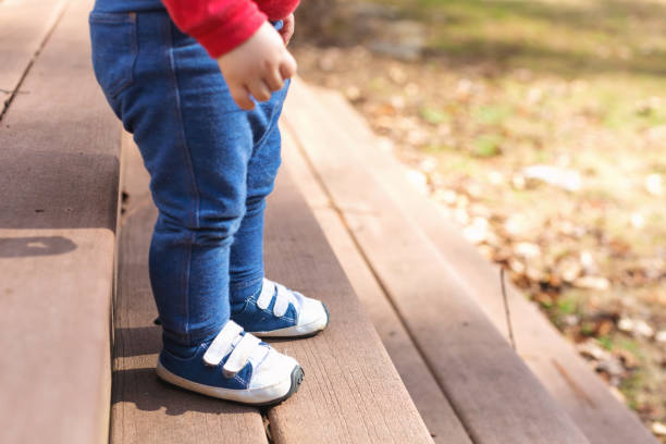 Toddler boy wearing his blue sneakers outside