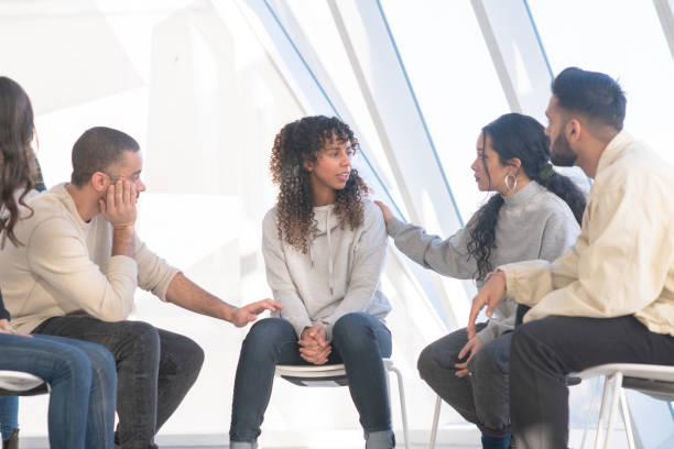 istock Young adults consoling a friend in group therapy 1133468577