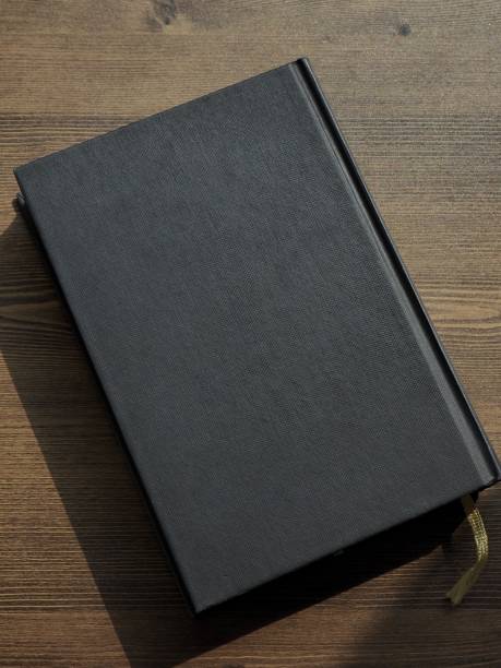 istock Wooden board and black book 1133471580