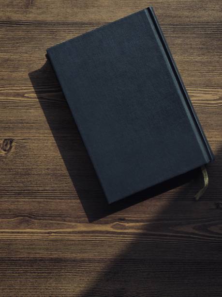 istock Wooden board and black book 1133471594