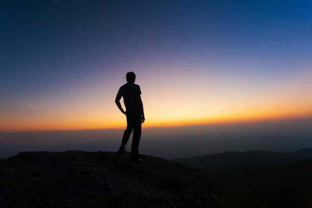 istock Man celebrating sunset looking at view in mountains 1133472090