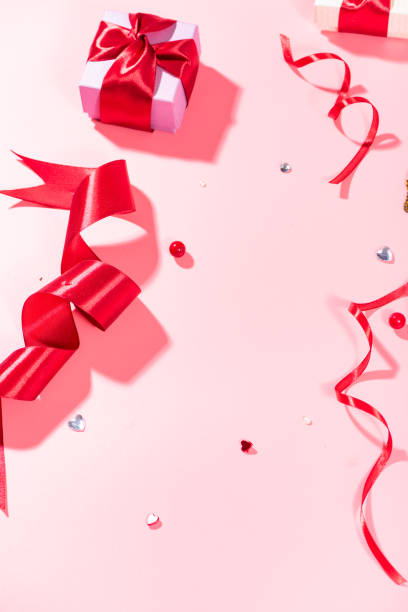 istock Red ribbons and beads on a pink background 1133481609