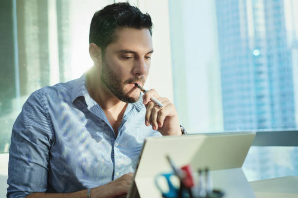 Ex-smoker Man Smoking Electronic Cigarette In Office While Working stock photo
