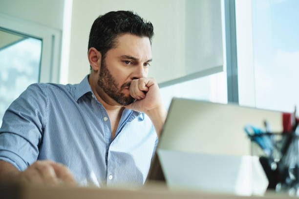 Worried Businessman Got Virus and Data Loss on Laptop Computer Angry Hispanic businessman working with laptop computer in office, losing patience. Anxious executive man under stress at work for technology problems and software pc virus. edgy man stock pictures, royalty-free photos & images