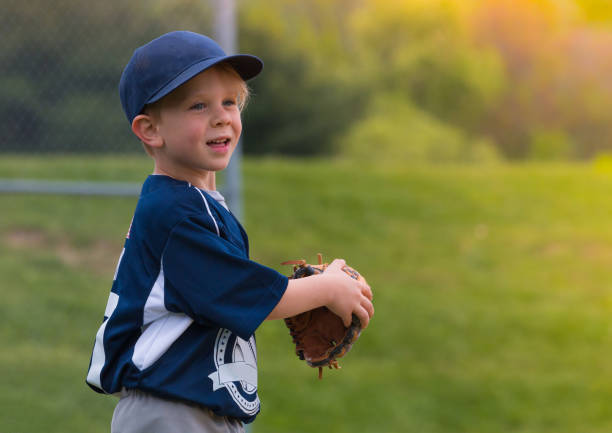 Children playing baseball on green grassy lawn