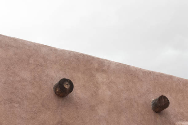 istock Exterior of red adobe building, two exposed vigas, grey cloudy skies 1133485217
