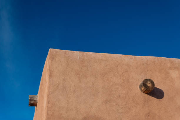 istock Red adobe exterior corner, exposed vigas, bright blue sky creative copy space 1133485289