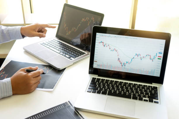 istock business man and woman sit at ther table looking at computer laptop 1133488185