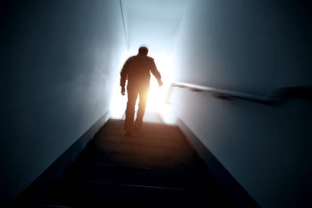 istock Man walking upstairs into the light. 1133493153