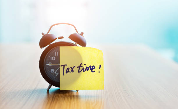Tax Time sticky note on alarm clock. Tax Time sticky note on alarm clock tax season photos stock pictures, royalty-free photos & images