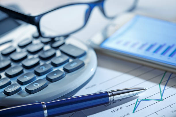 istock Calculator Ballpoint Pen And A Mobile Phone Resting On Top Of Chart 1133495111