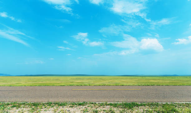 istock Side view of empty asphalt road and green field 1133497004