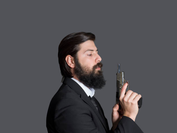 mann in anzug zielt auf eine waffe - bodyguard holding gun 20s stock-fotos und bilder