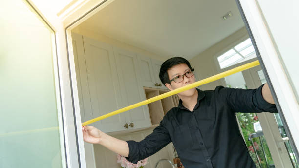 istock Young Asian worker man using tape measure on door frame in the kitchen. Home interior designer measuring elements on site. Housing design and construction concept 1133497314
