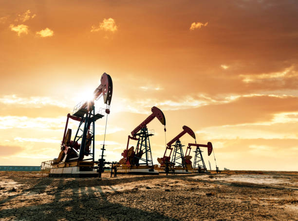 Oil pumps working under the sunrise sky stock photo