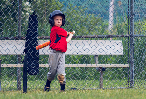 A baseball player takes practice swings while waiting for his turn to bat.
