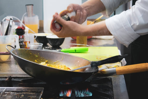istock Chef cooking with flame in a frying pan on a kitchen stove, Chef in restaurant kitchen at stove with pan 1133506954
