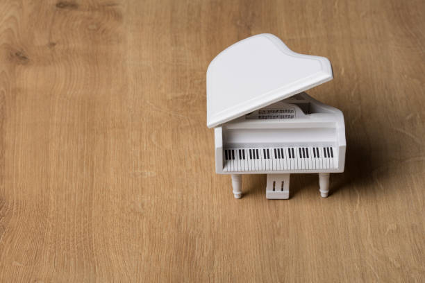 istock White tiny piano music close up on a wooden background 1133507876