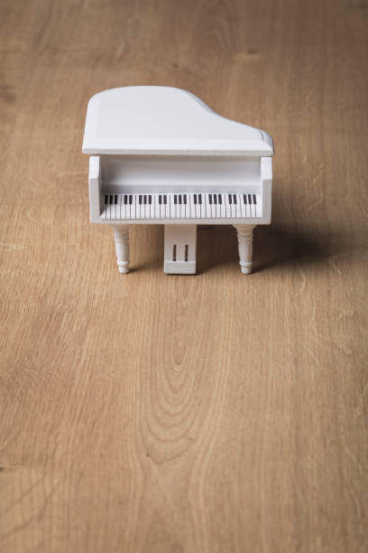istock White tiny piano music close up on a wooden background 1133507884