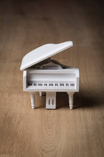 istock White tiny piano music close up on a wooden background 1133507893