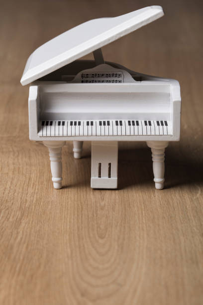 istock White tiny piano music close up on a wooden background 1133507900