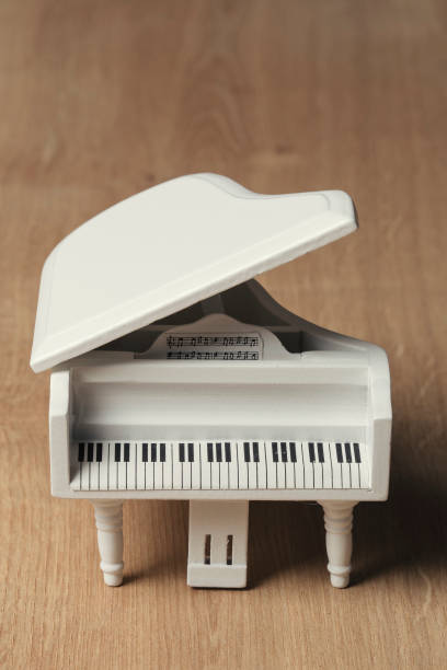 White tiny piano music close up on a wooden background