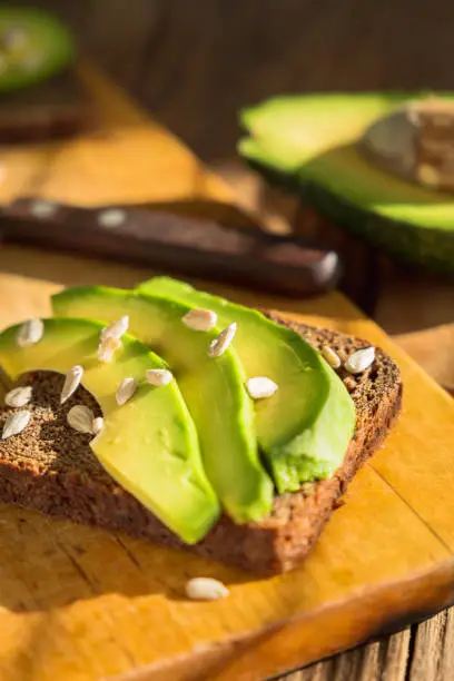 Breakfast avocado toast with sunflower seeds and rye black bread