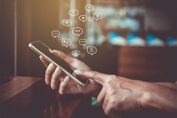 istock Women hand using smartphone typing, chatting conversation in chat box icons pop up. Social media maketing technology concept.Vintage soft color tone background. 1133508716