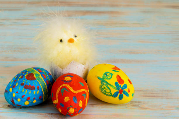 istock Easter baby chicken next to eggs on blue wooden background 1133514155