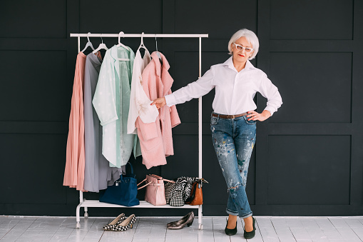 Senior lifestyle. Fashion clothes shopping. Confident elderly lady showing stylish wardrobe.
