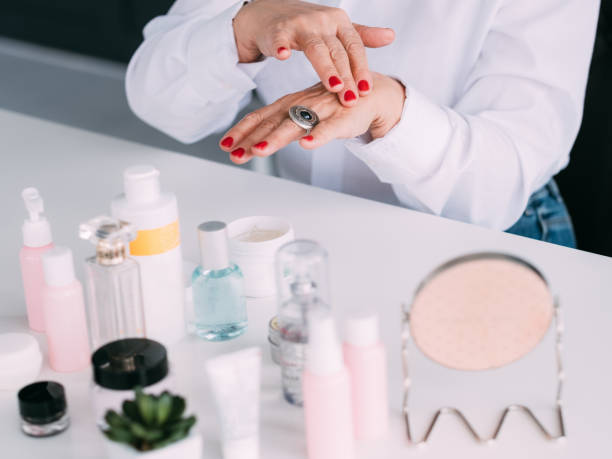 シニア女性の手化粧品レビュー美容製品 - human face rubbing women beauty treatment ストックフォトと画像