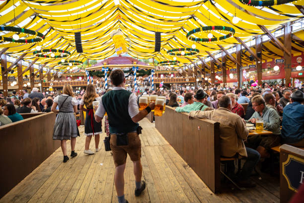 мюнхен, германия, октоберфест, официант, держащий пиво, интерьер палатки - oktoberfest стоковые фото и изображения