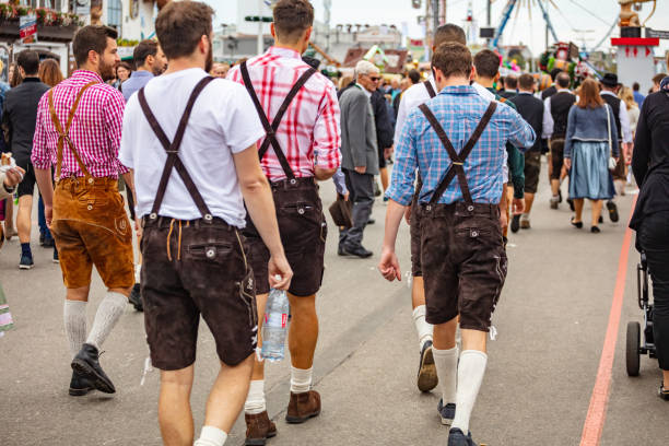 мюнхен, германия, октоберфест, группа молодых людей в традиционных костюмах ходьба - parks brewery стоковые �фото и изображения