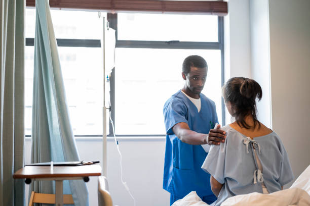 istock Male nurse with hand on woman's shoulder talking 1133516767