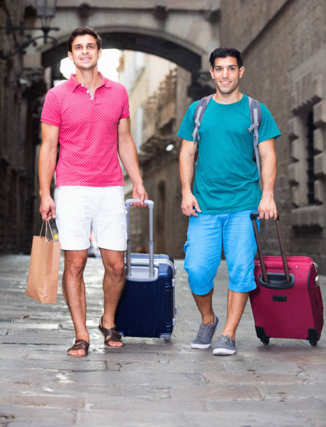 istock Men tourists are walking with suitcases in unknown city. 1133518069