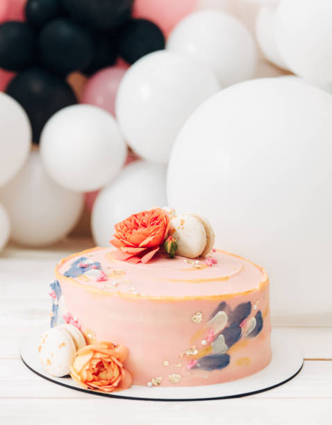 istock Birthday cake.Light pink with flowers and macaroon.Balloons background. 1133520447