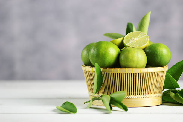 istock Fresh limes on white wooden background. Green limes. 1133520740