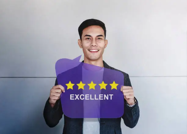 Photo of Customer Experiences Concept. Happy Client Showing Five Stars Rating and Positive Review on Speech Bubble Card. Client Satisfaction Surveys and Feedback