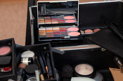 A set of professional cosmetics in the box open close up with content in the studio of visage, dials with a brush from the palette of the shadows.