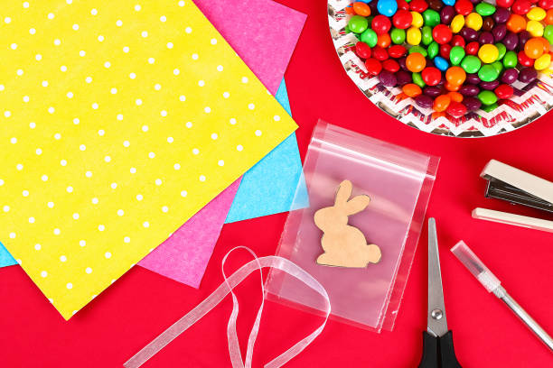 istock Diy Easter wrapping package sweets in a bag with a cut out bunny silhouette on a red background. 1133523293