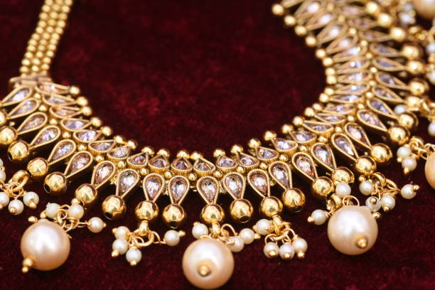 istock Designer beautiful golden necklace closeup macro image on red background. 1133524741