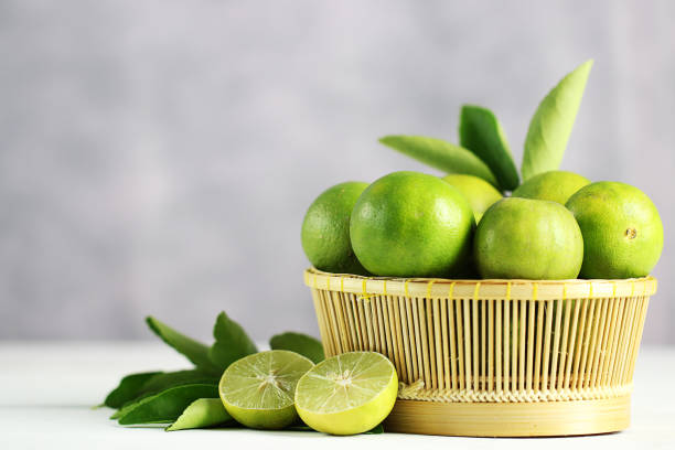 istock Fresh limes on white wooden background. Green limes. 1133526141