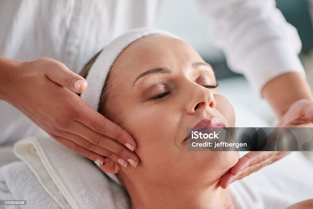 We just want to help you banish wrinkles Shot of a mature woman getting a facial treatment at a spa Facial Mask - Beauty Product Stock Photo