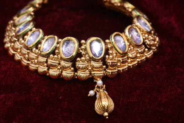 istock Designer beautiful golden necklace closeup macro image on red background. 1133526552