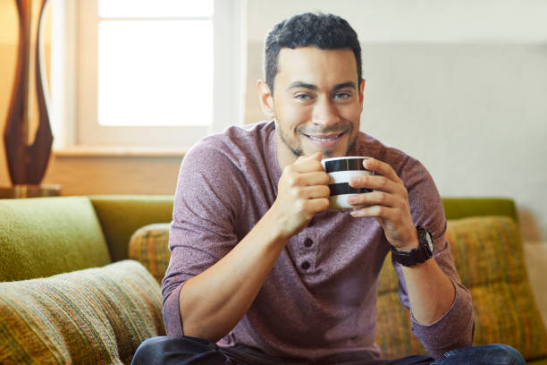 istock Portrait of smiling man having coffee on couch 1133527266